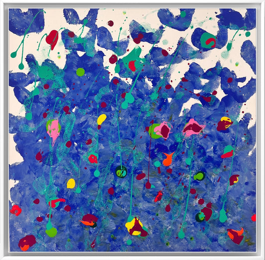 Abstract painting with bold, hand-painted blue strokes forming a textured background. Over the blue base are splashes, drips, and dots of bright colors including teal, red, yellow, pink, green, and orange. The paint appears layered and spontaneous, creating a dynamic, energetic composition reminiscent of a floral field or an underwater scene. The upper portion has more white space and scattered shapes, while the lower half is densely packed with colour.